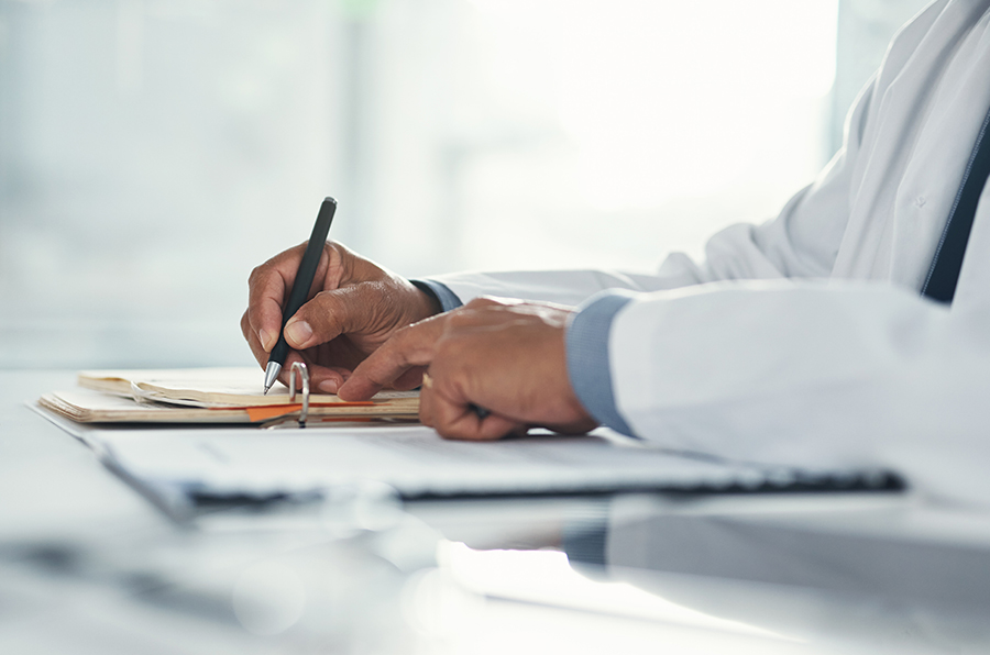 A doctor holding a pen and writing something