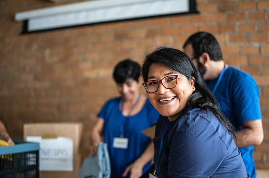 A woman wearing ID card and eye glasses and smiling